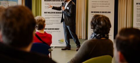 Medewerker van de gemeente geeft een presentatie aan een groep mensen