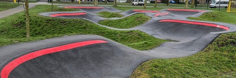 Een pumtrack metrode banen over het asfalt.